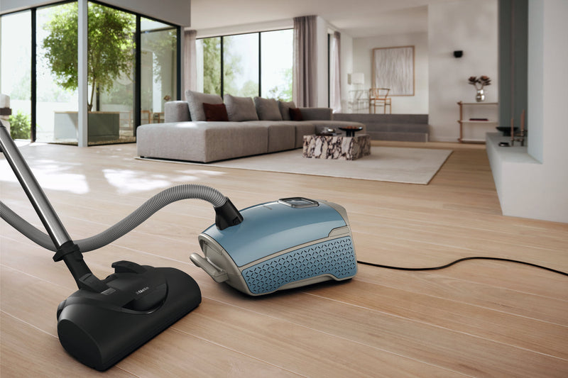 Miele Guard L1 Electro Nordic Blue canister vacuum cleaning a modern living room — German-engineered for 15+ year lifespans, sold and serviced at Avon Vacuums in Avon, CT since 1972
