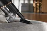 Miele HX-UN Wide Upholstery Nozzle for Cordless Sticks — shown cleaning a sofa cushion