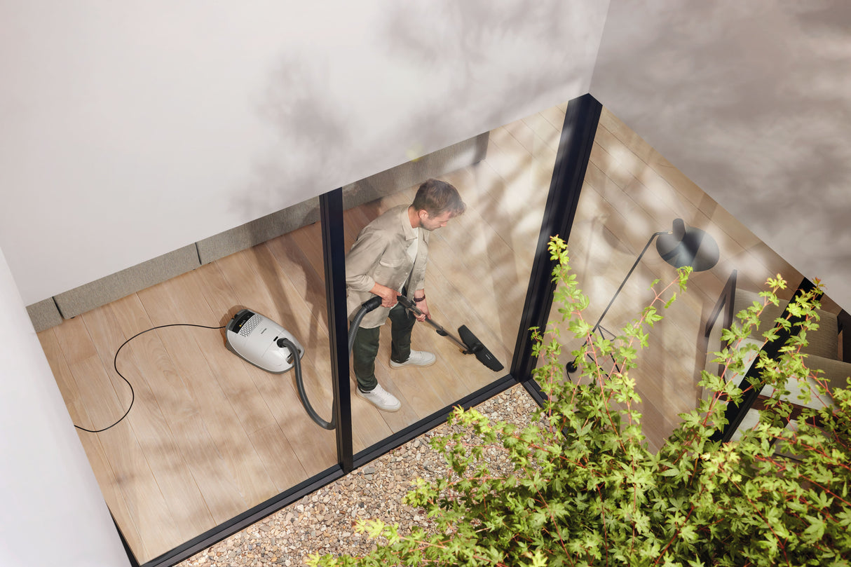 Miele Guard M1 Parquet XL canister vacuum in use in a modern living room