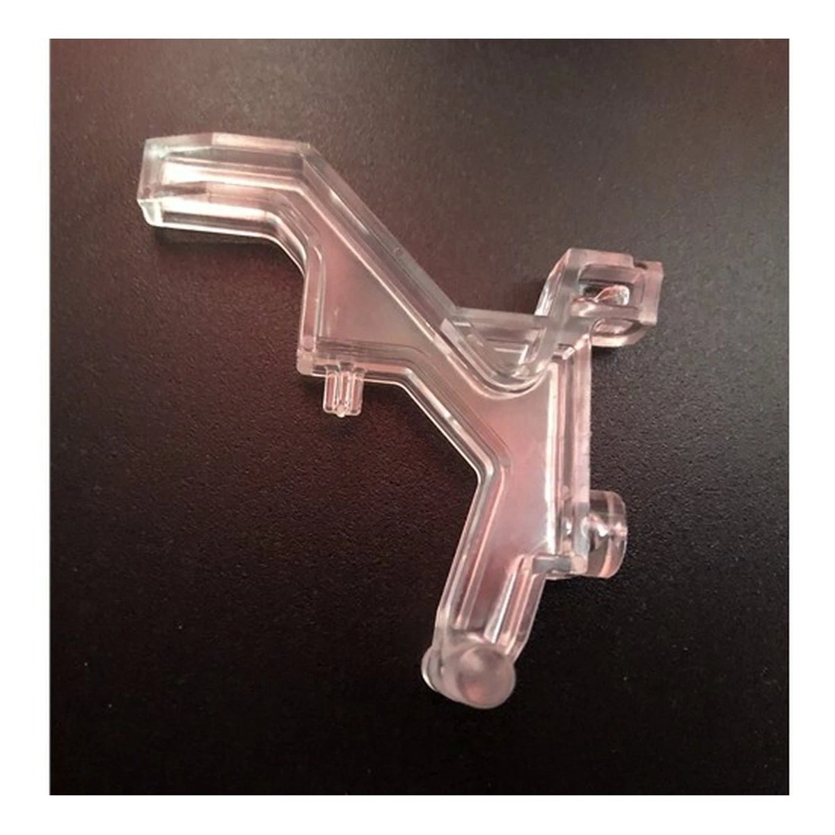 Clear plastic Miele SEB236 interlock with an angled arm and mounting features on a dark surface